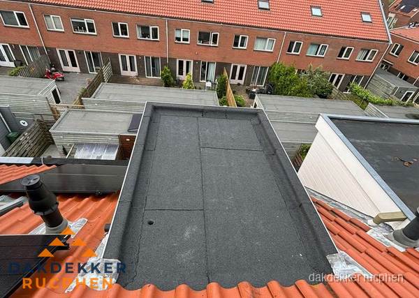 Plat dak met bitumen bedekking naast dakkapel in Rucphen