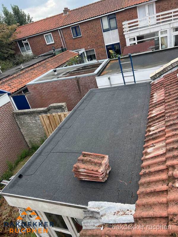 Plat dak aanbouw met bitumen naast schuin pannendak in Rucphen