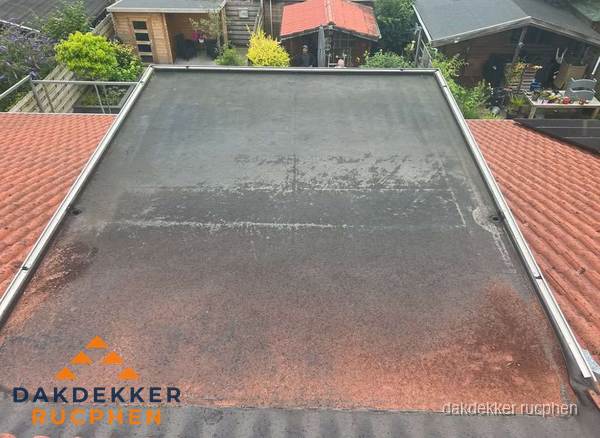 Verouderd plat dak met slijtage tussen schuine daken in Rucphen Verouderd plat dak met slijtage tussen schuine daken in Rucphen